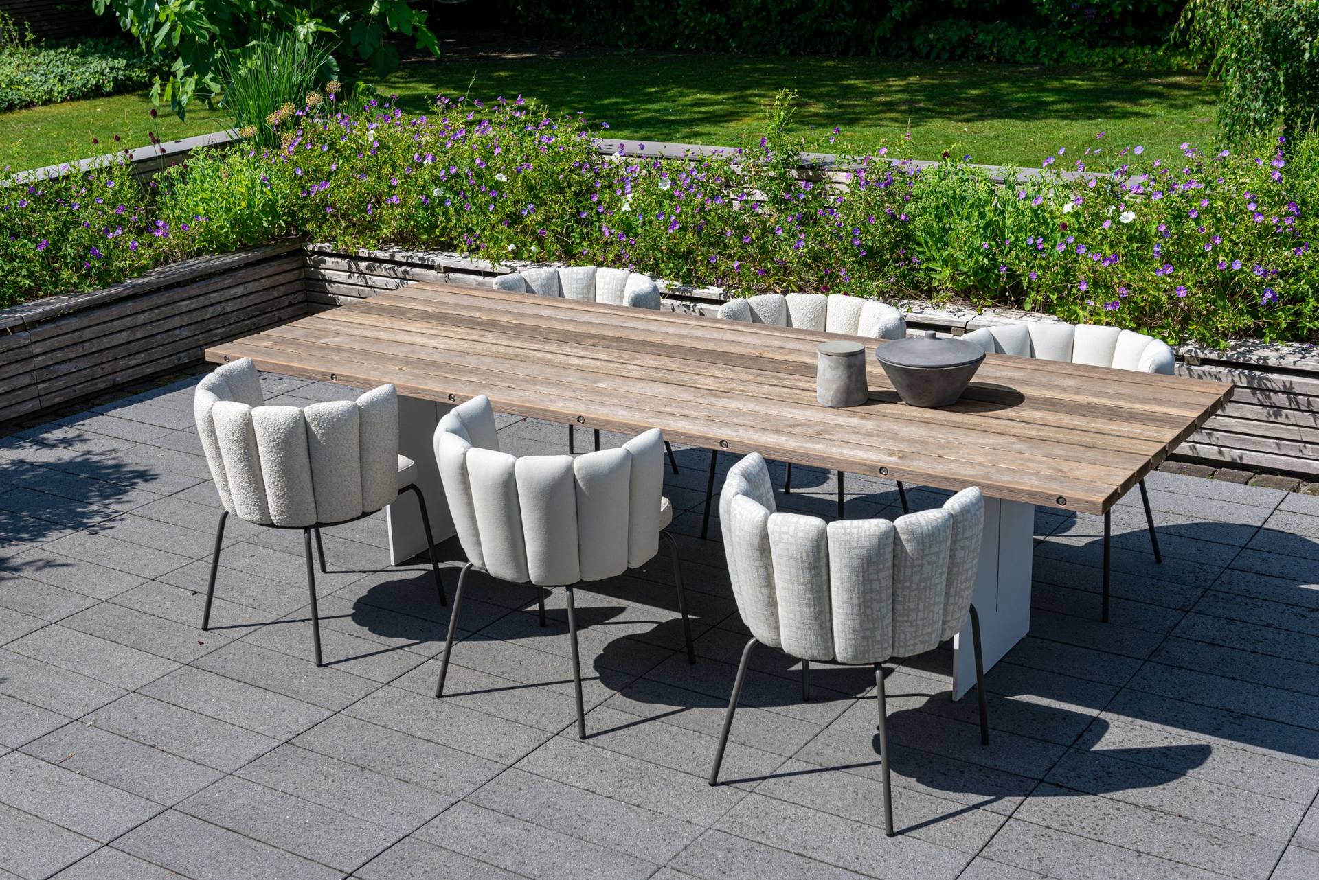 Rote GAIA Outdoor Stühle am Gartentisch zwischen Stauden