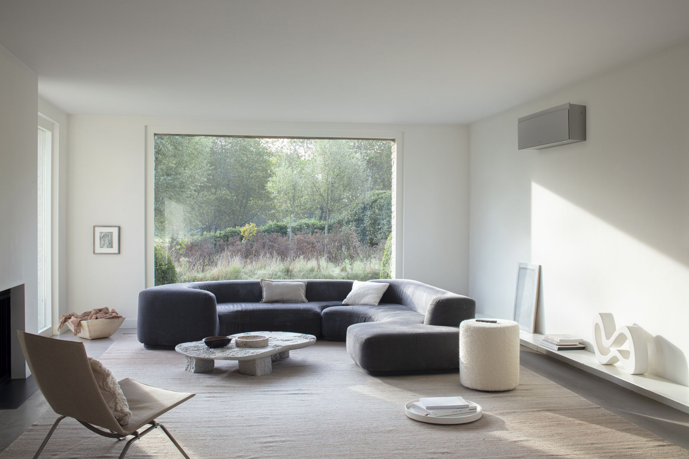 Daikin Emura 3 im Wohnzimmer mit dunkler Sofalandschaft